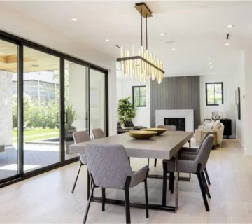 Modern dining room with wooden table, upholstered chairs and pendant lighting
