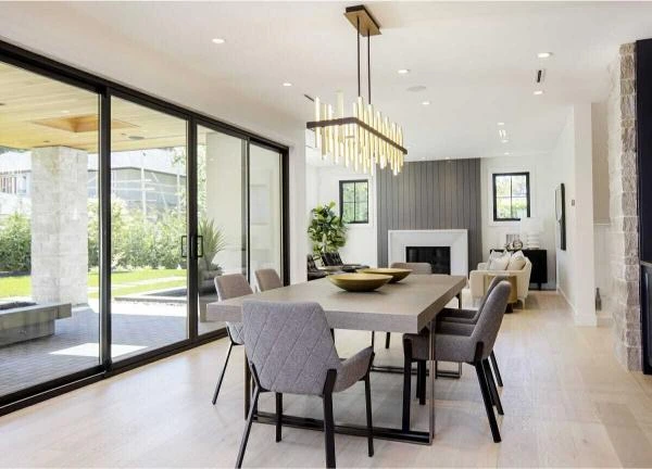 Modern dining room with wooden table, upholstered chairs and pendant lighting